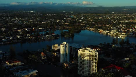 Aerial-view-from-Gold-Coast-suburbs-to-cloudy-hinterland-at-sunset