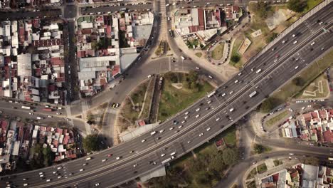 A-dynamic-top-down-ascending-aerial-shot-above-a-busy-highway-on-top-of-a-roundabout