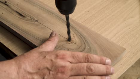 Shot-of-a-person-drilling-in-a-wooden-plank