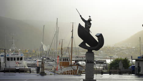 Fangstmonument---Skulptur-Mit-Verkehr-Und-Hafen-Im-Hintergrund-In-Tromso,-Norwegen