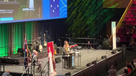 Lord-Mayor-Adrian-Schrinner-on-stage,-giving-speech-to-the-candidates-who-attend-the-Brisbane-supersized-citizenship-ceremony-in-convention-and-exhibition-centre