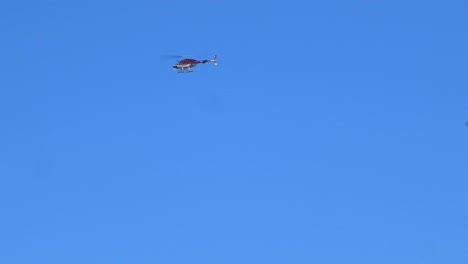 Vista-Lejana-De-Un-Helicóptero-Privado-Volando,-Cielo-Azul-Claro-En-El-Fondo,-Las-Américas,-Tenerife,-España,-Día-Soleado-De-Verano,-Tiro-De-Seguimiento-De-Mano