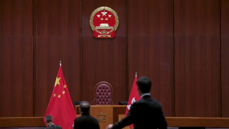 Lawmakers-are-seen-at-the-Legislative-Council-building's-main-chamber-as-the-Chinese-emblem-is-seen-above-the-People's-Republic-of-China-flag-in-the-background