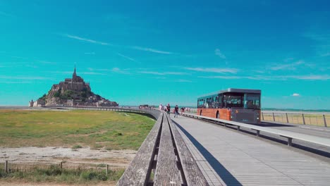 People,-buses-and-cyclists-use-the-famous-bridge-Passerelle-by-Mont-Saint-Michel