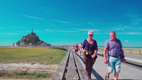 Tourists-walking-on-the-Passerelle-Mont-Saint-Michel-during-a-windy-day
