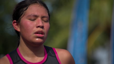 Close-up-of-the-face-of-a-latin-young-teenage-athlete-completely-exhausted-jogging-to-the-finish-line