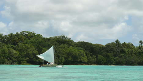 Traditional-outrigger-canoe,-or-pirogue,-sails-along-Upi-Bay-coast,-Isle-of-Pines