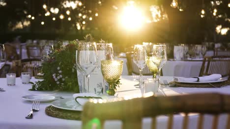 Slider-Shot-Of-Restaurant's-Table-Set-Up-With-Wine-Glasses-And-White-Plates-in-a-weeding