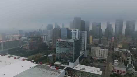Aerial-view-around-the-Marriott-Marquis-hotel,-foggy-day-in-Houston,-USA---orbit,-drone-shot