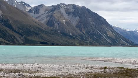 Birds-flying-low-over-turquoise-water-of-alpine-Lake-in-New-Zealand