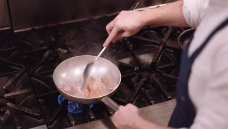 Cook-stirs-with-a-spoon-through-a-frying-pan-on-the-fire-in-which-the-meat-is-cooked