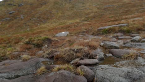 The-camera-slowly-tilts-from-small-mountain-stream-to-reveal-the-summit-of-Cul-Mor-mountain-in-the-Scottish-Highlands