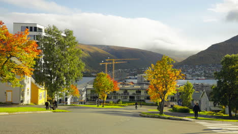 Colorful-Trees-And-Busy-People-In-A-Neighborhood-On-A-Typical-Day-In-Autumn-In-Tromso,-Norway