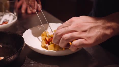 Koch-In-Der-Küche-Eines-Italienischen-Restaurants-Legt-Das-Brathähnchen-Und-Die-Rote-Tomate-Mit-Nudeln-Auf-Den-Teller