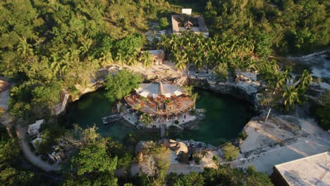 Aerial-shot-of-Casa-Tortu-structure-inside-of-a-lake-with-trees-surrounding