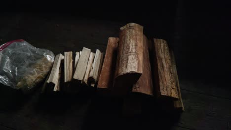 Ein-Langsamer-Schwenk-über-Einen-Haufen-Holzscheite-Für-Brennholz,-Gehacktes-Anzündholz-Und-Feueranzünder-In-Einer-Plastiktüte