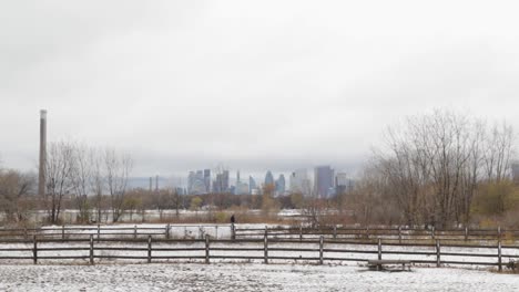 Static-shot-dowtown-Toronto,-Canda-covered-with-white-snow-city-skyline-in-the-background-from-lakeside-beach-on-a-cloudy-day