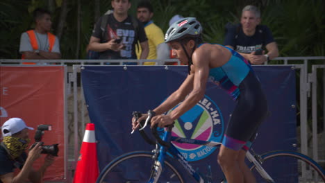 Latin-teenage-boy-competitor-getting-off-his-bike-while-entering-the-transition-zone-at-a-triathlon-competition