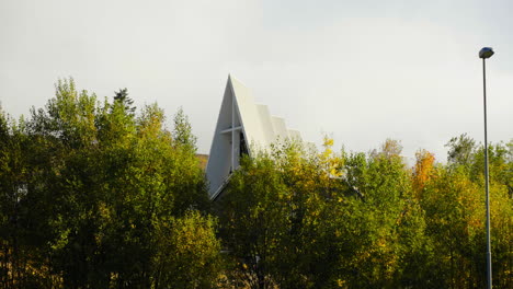 Arquitectura-De-Forma-Angular-De-La-Catedral-ártica-Detrás-De-Las-Hojas-De-Otoño-En-Tromso,-Noruega