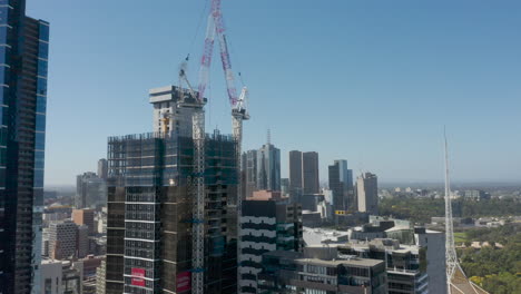 Pan-tracking-of-construction-crane-of-a-new-building-being-developed-in-Melbourne,-Australia