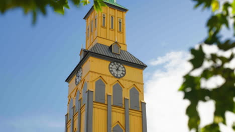 Tromso-Cathedral-Clock-Tower-Behind-The-Tree-Leaves-In-Daytime-In-Tromso,-Norway