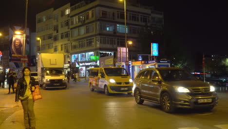 Busy-Istanbul-Crossing-at-Night-Full-of-Cars,-Buses-and-Walking-People