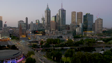 Aerial-approach-of-Melbourne-CBD-at-dusk-with-Fed-Square-and-the-Yarra-River-in-the-foreground