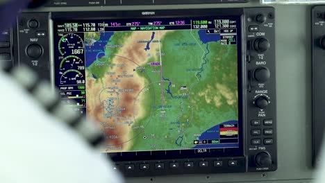 Commuter-Cessna-airplane-Co-pilot-manually-programming-position-on-GPS-receiver-map,-Close-up-handheld-shot