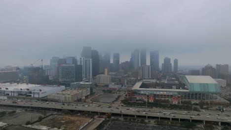 Aerial-view-of-the-Minute-maid-park-and-the-skyline,-in-foggy-Houston,-USA---tracking,-drone-shot