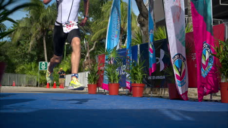 Slow-motion-of-a-male-young-athlete-in-a-black-and-white-suite-sprinting-to-the-finish-line-of-a-triathlon-competition