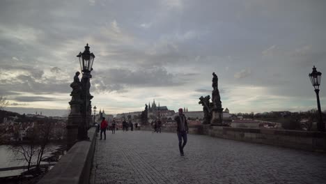 People-walking-on-Charles-Bridge-or-Karluv-most-in-Prague,-Czech-Republic,-wide-angle-view