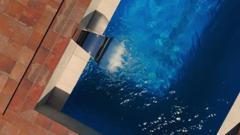 Wasser,-Das-Aus-Einem-Stahlbrunnen-Eines-Luxuriösen-Hydromassage-Swimmingpools-Fließt