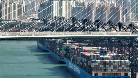 Three-Cosco-Shipping-vessels-moored-in-a-row-at-ACT-Container-terminal-Hongkong-with-traffic-on-the-Stonecutters-bridge-and-Kwai-Ching-district-in-the-backdrop