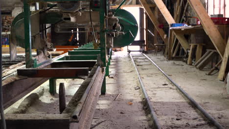 Empty-sawmill-with-bandsaw-equipment-and-plank-pile,-handheld-dolly-in