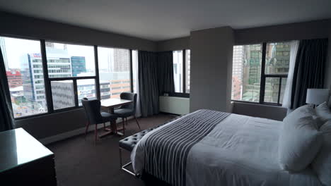 Ein-Geräumiges-Und-Elegant-Gestaltetes-Hotelzimmer-Mit-Einem-Kingsize-Bett,-Das-In-Weiche-Bettwäsche-Gehüllt-Und-Mit-Kissen-Und-Einer-Kuscheligen-Decke-Geschmückt-Ist