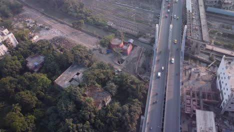 Aerial-drone-shot-flying-over-Majerhat-cable-bridge-road-close-to-construction-site-of-Majerhat-metro-station,-Kolkata