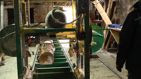 Person-working-in-sawmill-with-special-equipment-for-log-cutting