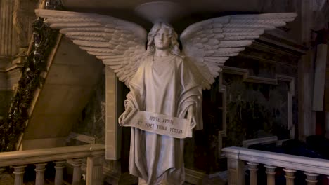 Life-size-marble-statue-of-an-angel-in-catholic-Candelária-church-with-written-in-Latin-on-a-banner-in-hands-in-front-of-the-altar-saying-Incline-thy-ear,-and-receive-the-words-of-understanding