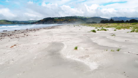 Warrington-domain-beach-in-New-Zealand,-low-dolly-in-over-dunes