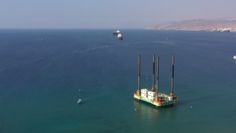 Offshore-Self-elevating-Platform-or-SEP-on-Fore-Large-Columns-For-Marine-Drilling-in-Eilat-city,-Israel---Aerial-Orbiting-Around