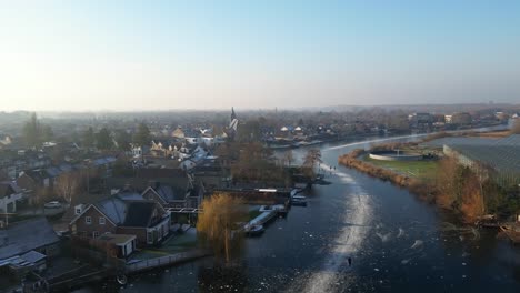Aerial-Ascending-View-Of-Locals-Ice-Skating-Over-Frozen-Canals-In-Hendrik-Ido-Ambacht