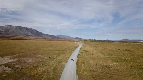 Off-road-vehicle-on-remote-unpaved-road-in-sunny-New-Zealand