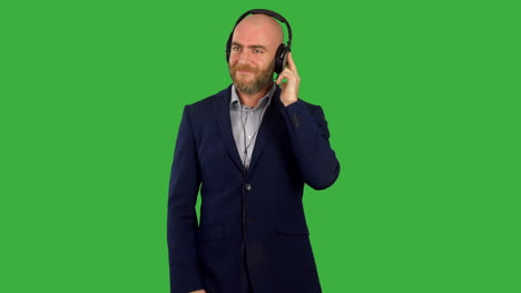 A-businessman-listinging-to-music-on-headphones-and-dancing-on-green-screen