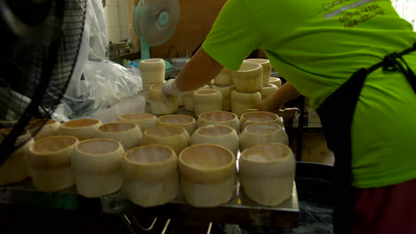 Thailand,-Bangkok---13-August-2022:-Woman-worker-counting-coconut-shell-with-fresh-pulp-in-it-ready-lo-be-filled-with-jelly-to-make-coco-jelly,-famous-thai-food