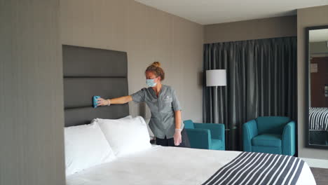 The-maid-efficiently-goes-about-her-tasks,-tidying-up-the-hotel-room-with-precision-and-care,-by-wiping-and-cleaning-everything-in-a-hotel-room