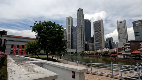 Downtown-Singapore-With-Skyscrapers,-Canal-and-Walking-Bridge,-Pan-shot