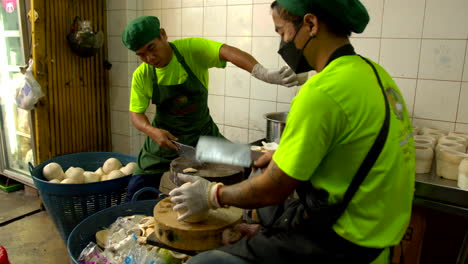Thailand,-Bangkok---13.-August-2022:-Herstellung-Von-Kokosgelee-Mit-Zwei-Männlichen-Arbeitern,-Die-Die-Schale-Für-Das-Gelee-Vorbereiten,-Das-Die-Obere-Grün-Geschälte-Kokosnuss-Schneidet