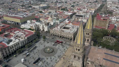 Drone-Rises-in-Front-of-Historic-Guadalajara-square-with-city-in-background,-Mexico-Catholic-Church