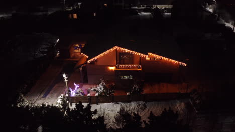 Night-aerial-view-of-the-house-exterior-lit-and-decorated-with-beautiful-lighting-during-Christmas