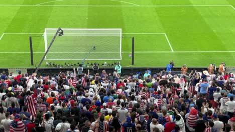 Football-fans-chanting-happily-support-football-team-USA-couple-family-friends-sit-in-seat-back-of-the-gate-applaud-relax-in-a-scenic-view-wide-angel-camera-is-recording-Birdseye-in-the-stadium